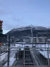 Bybaneperrong om vinteren med snødekt fjell og bolighus i bakgrunnen
