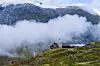 Tungestølen turisthytte omgitt av tåke, fjell og bre i Langedalen i Luster.