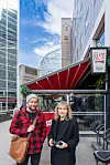 Even Smith Wergeland og Johanne Borthne står foran en restaurant med rødt tak i en bygate med høye bygninger og Gallagher-skilt.