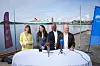 Fire politikere holder pressekonferanse ved et bord med mikrofoner på en kai i Oslo.