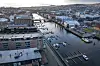 Dronebilde av Nidelva med brygger, broer og bygninger i Trondheim en vinterdag.