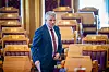 Bjørnar Skjæran står i en tom stortingssal med trepanel og gule seter etter spørretimen.