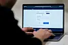 Person bruker en laptop med ID-porten-innlogging på skjermen.