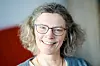 Portrett av Anne Sverdrup-Thygeson med briller og smil under en forlagssamling i Oslo.