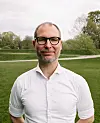 Fredrik Holth foran en grønn park.