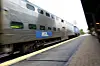 Et sølvfarget Metra-tog kjører langs plattformen på stasjonen i Arlington Heights.