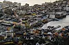 Aerial view of Bergen with colorful waterfront buildings, Bryggen and boats in the harbor at dusk.