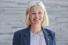 Sigrun Aasland smiler foran en grå trevegg under et pressetreff i Oslo.